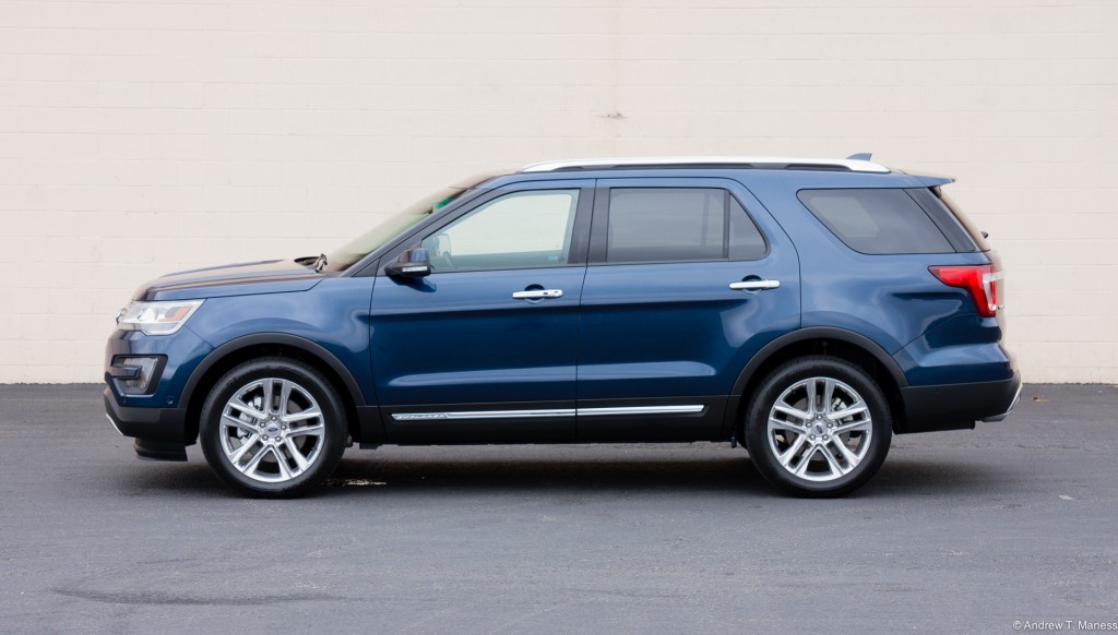 A Dark Blue Ford Explorer parked in front of a white wall.