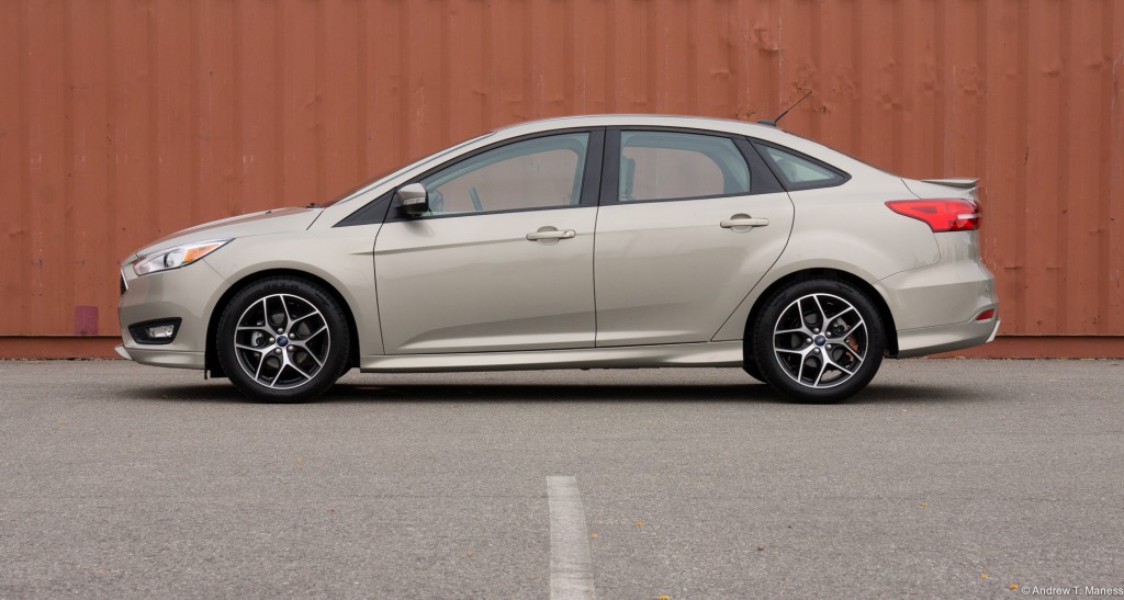 A Metallic Sand Ford Focus sedan parked in front of a storage container.