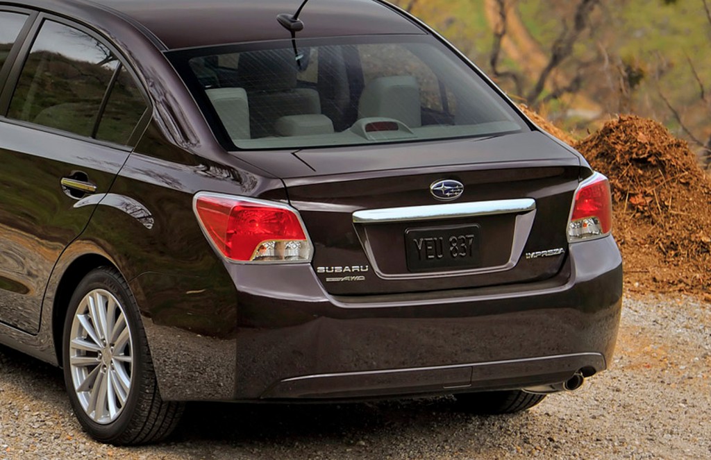 The rear end of a plum 2013 Subaru Impreza sedan.